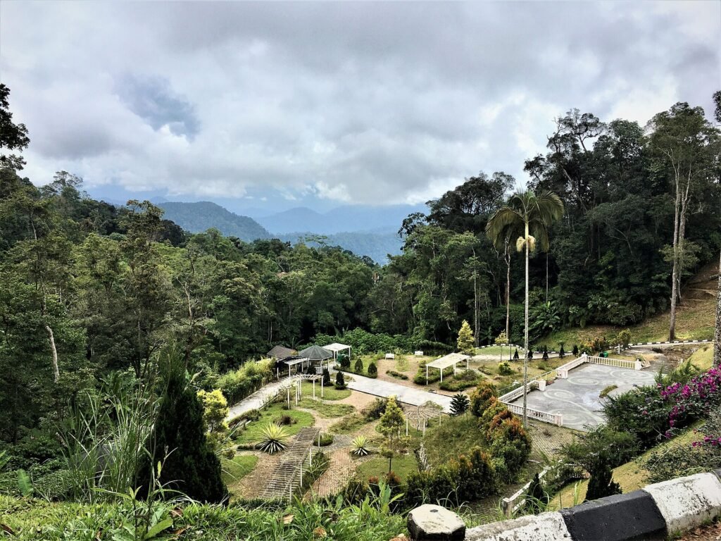 Garden and colonial-style buildings among forested hills at Fraser's Hill